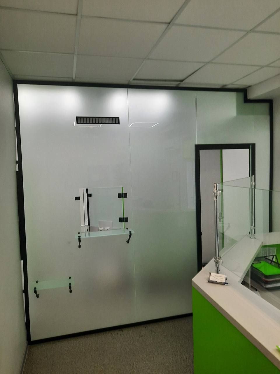 Frosted glass partition with a black-framed door in a bank