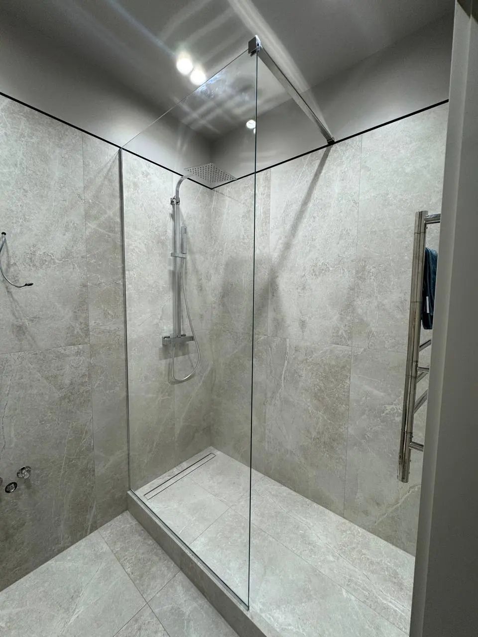 Shower zone with a fixed glass panel and a diagonal brace to the ceiling