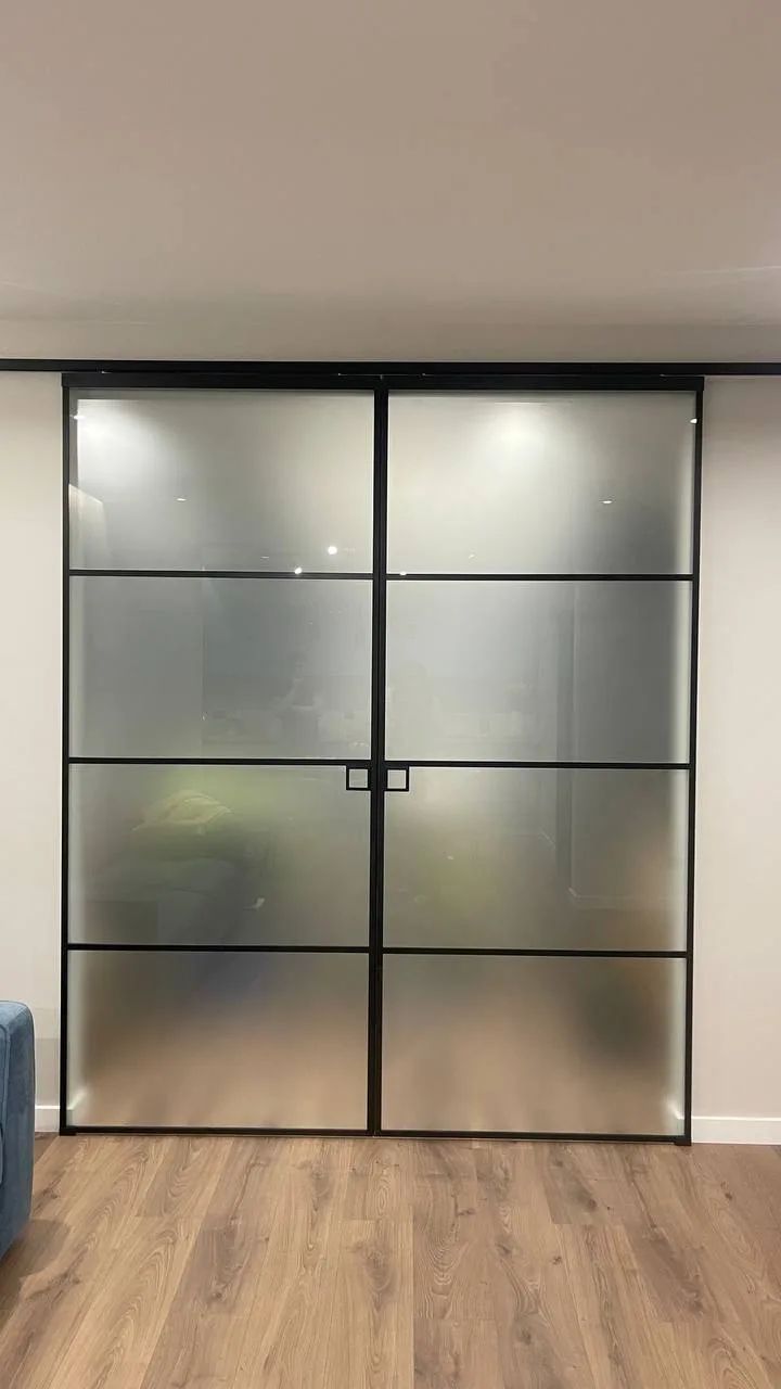 Two-leaf sliding partition with a black profile and frosted glass