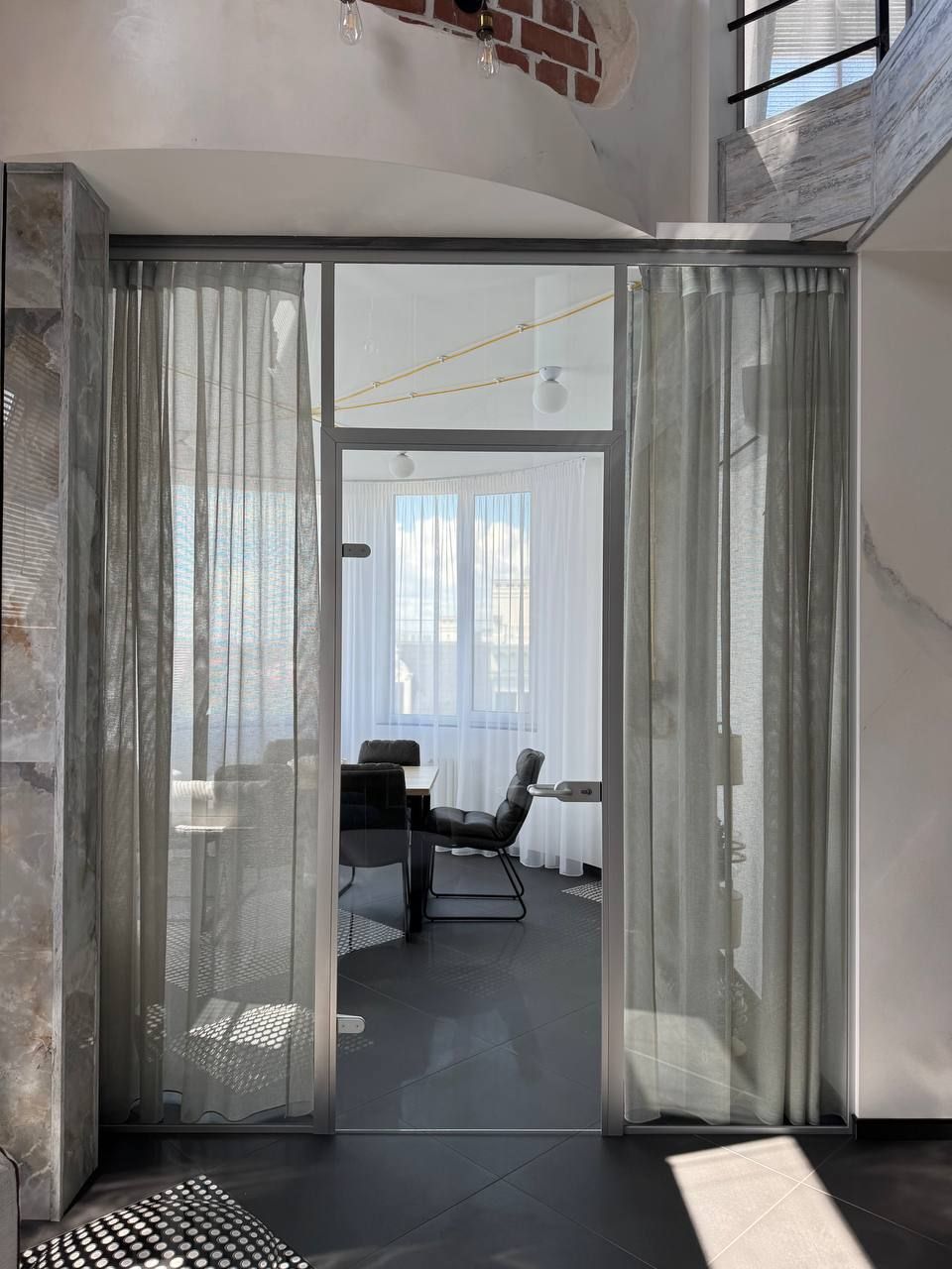 Glass partition with a door in front of a study in an apartment